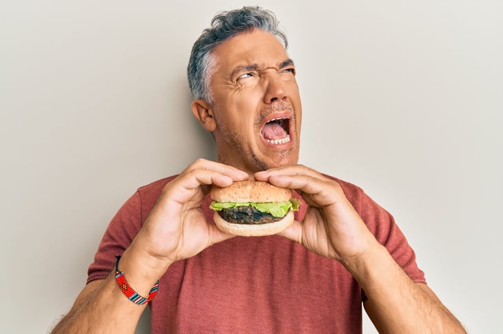 Unhappy man eating a burger