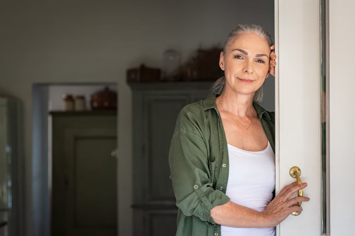 Older woman in a wide doorway of her home