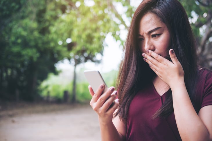 Upset woman looking at cellphone