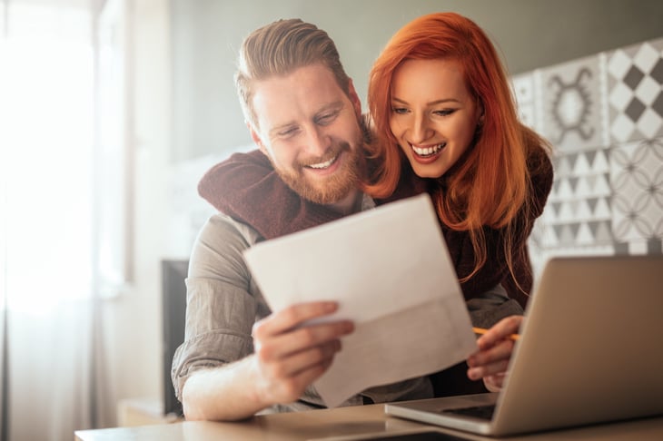 Happy couple looking at homeowners insurance savings