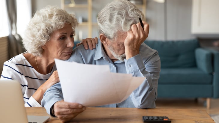 Worried senior couple reviewing documents
