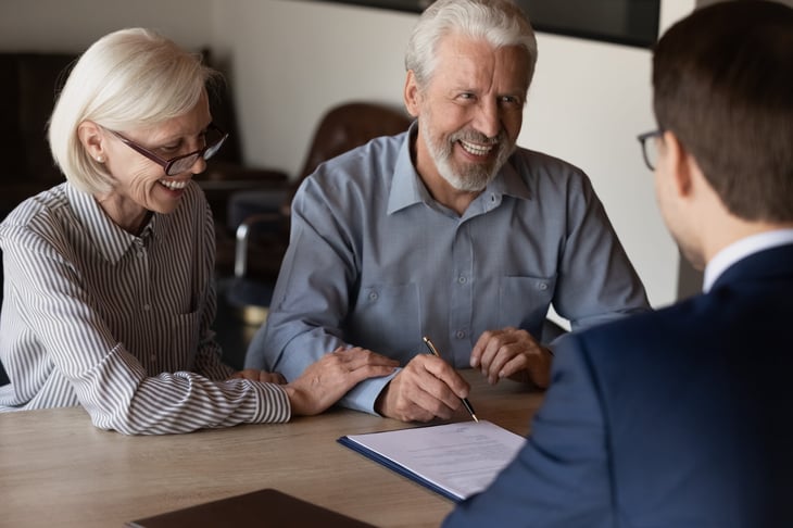 older couple signing paper