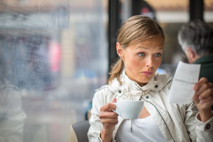 Woman looking at expensive restaurant bill