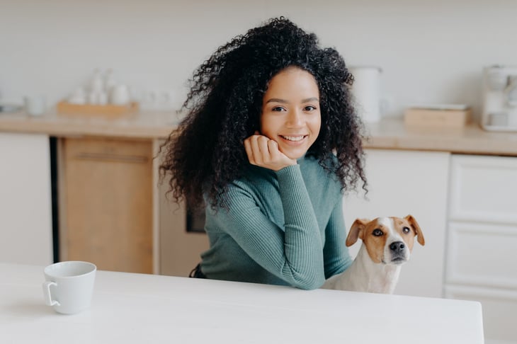 Woman sitting at her kitchen table with her dog