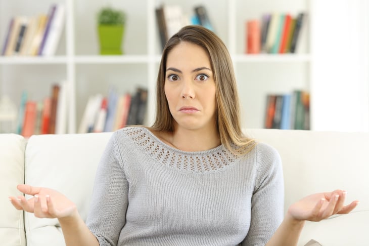 Confused woman shrugging her shoulders