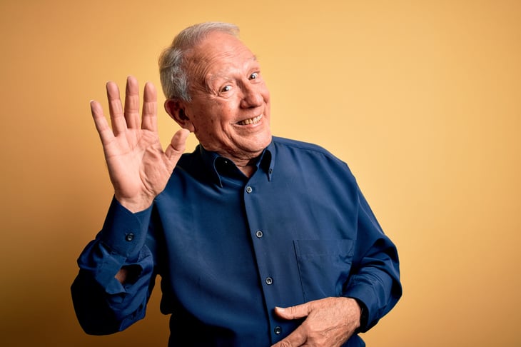 Smirking senior waving goodbye
