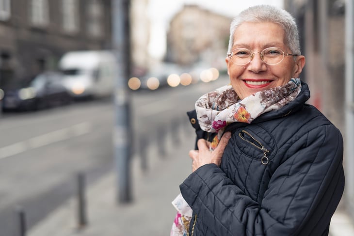 Senior standing on a sidewalk in a city