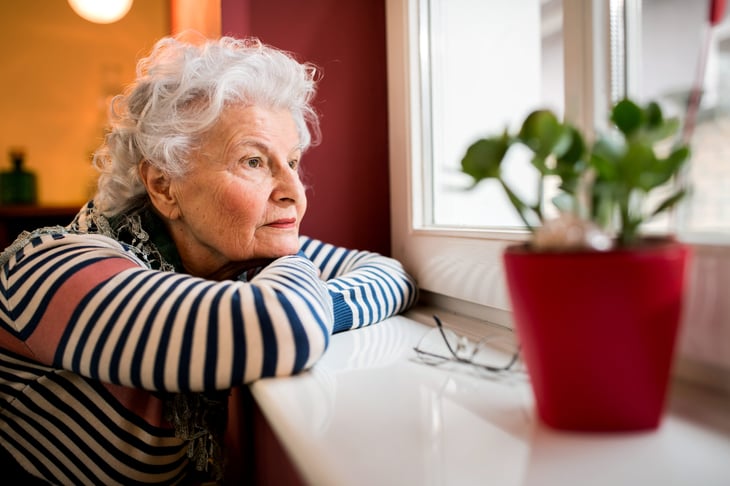 Sad senior looking out a window