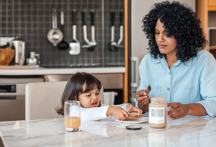 Mother and daughter with peanut butter sandwich