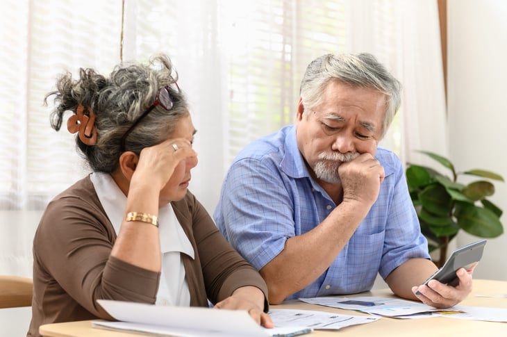 Unhappy senior couple doing taxes