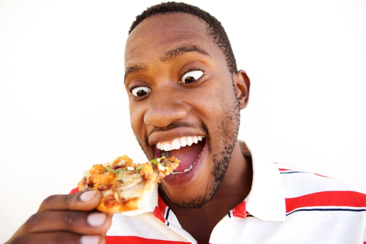 Excited man eating pizza