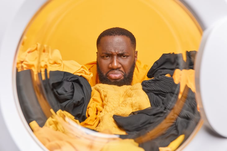 Unhappy man in front of laundry