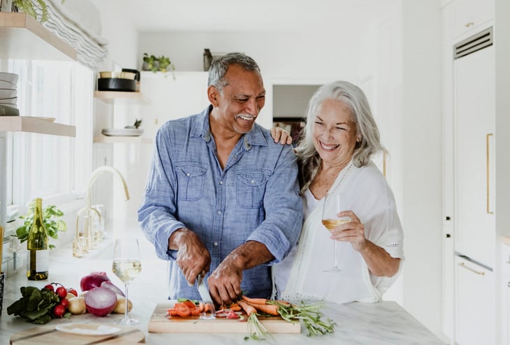 An older couple is preparing a healthy meal in their kitchen