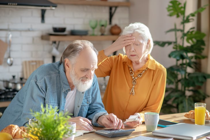 Worried retirees reviewing their finances