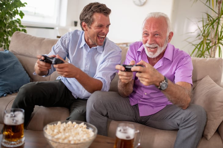 Older father and son playing a video game