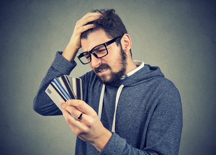 Stressed man considering his credit card debt