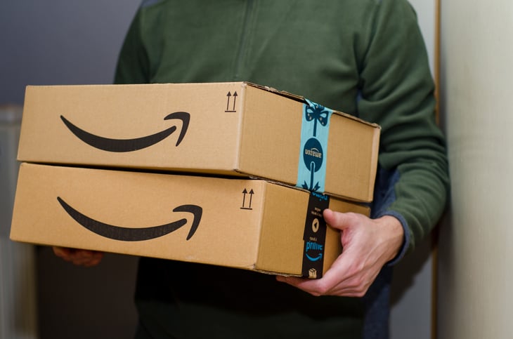 A man holds boxes from Amazon