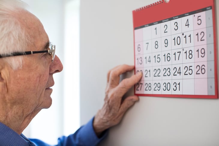 elderly man looking at the calendar