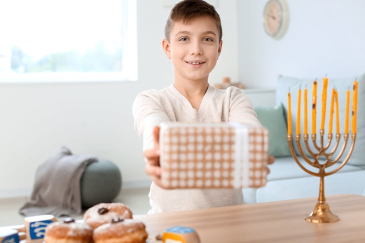 Child giving a Hanukkah gift