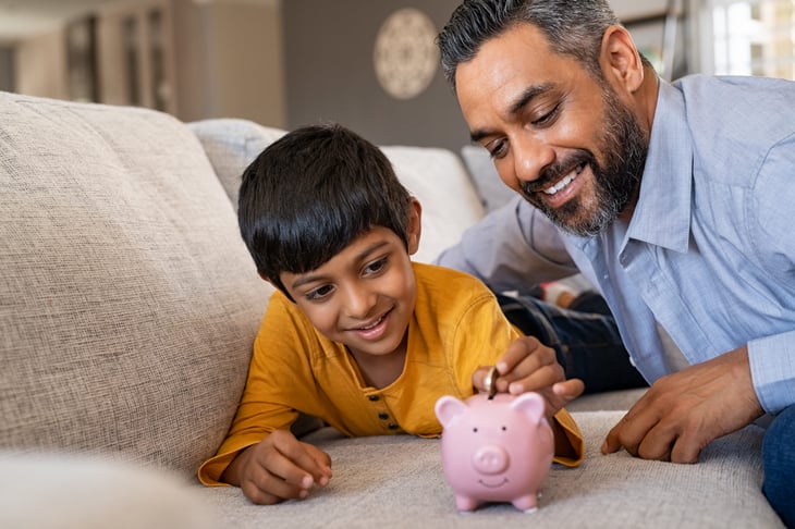 Father and son with piggy bank