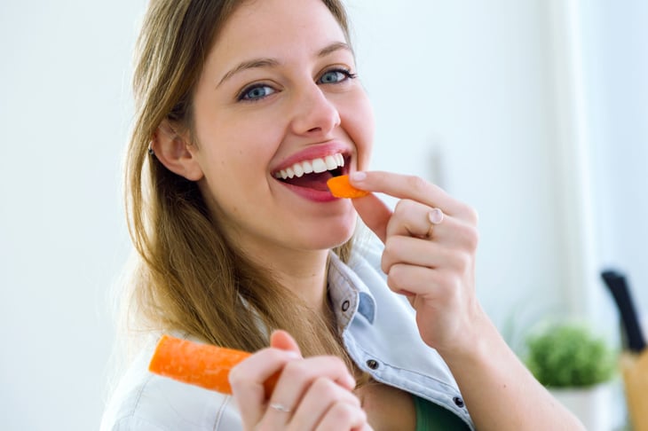 Woman eating a carrot
