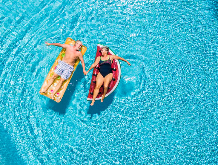 Seniors holding hands in pool