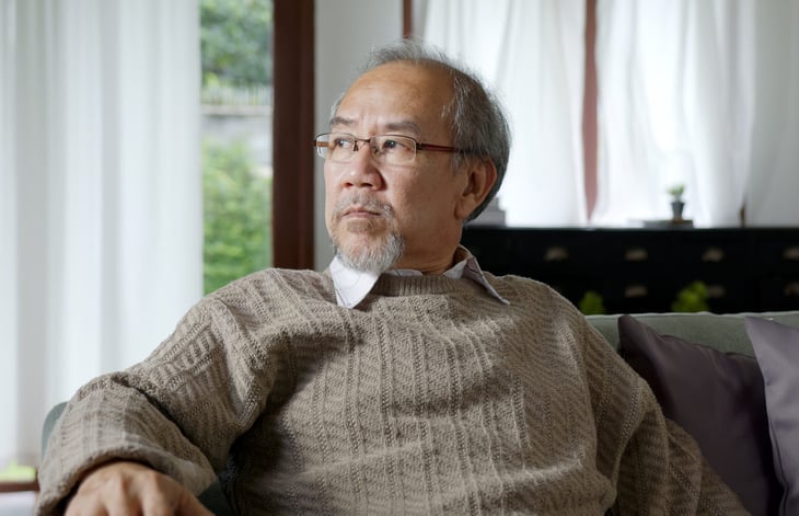 Older man sits in his living room