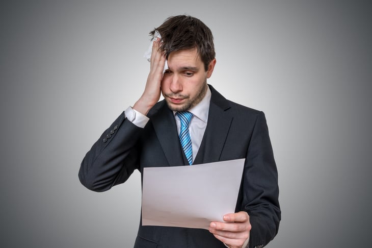 Stressed man looking at IRS paperwork
