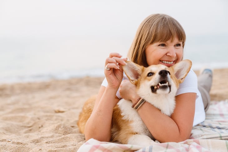 Retired woman on the beach with her dog
