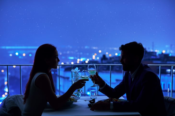 Couple having a date outdoors at night with wine and stars