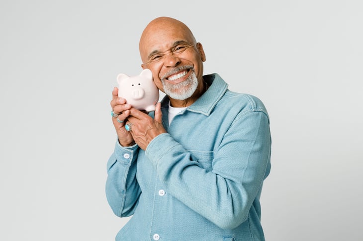 Happy pensioner holding his savings