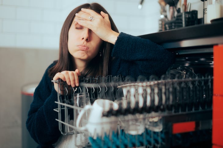 Upset woman by her dishwasher
