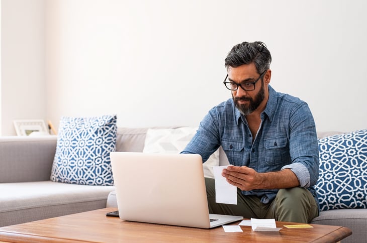 Man stressed and worried about filing taxes correctly on laptop online