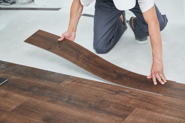 Worker laying vinyl flooring