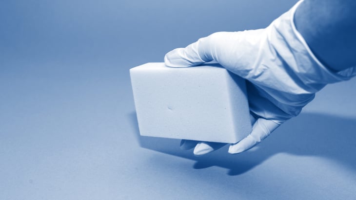Gloved hand cleaning with a magic eraser