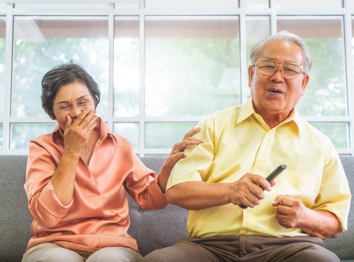Baby boomers laughing while watching TV