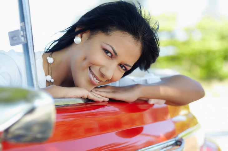 Happy woman in a red car