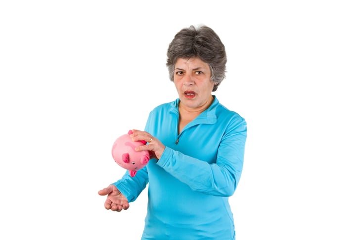 Senior woman with empty piggy bank