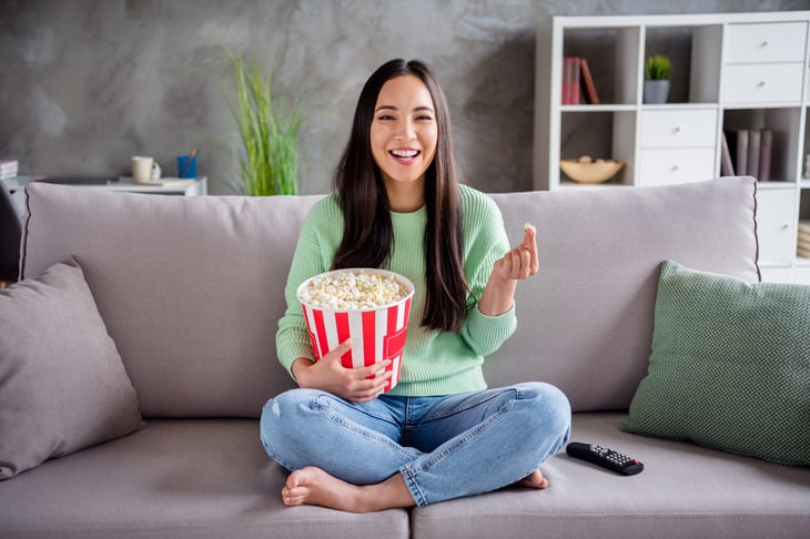Woman watching a movie or streaming TV with popcorn