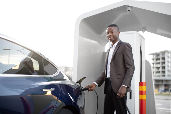Young man recharging an EV car