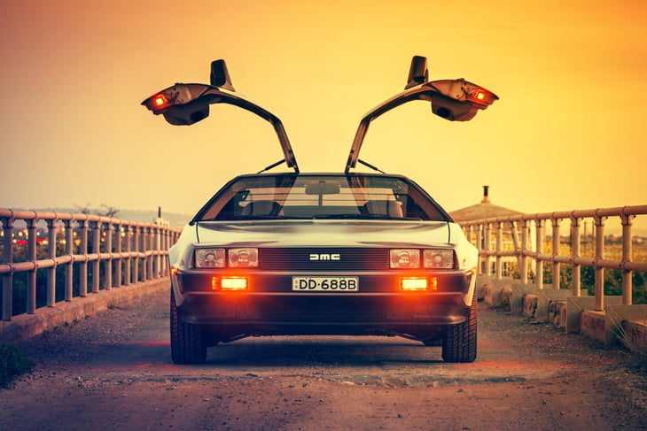 Adelaide, Australia - September 7, 2013: DeLorean DMC-12 1981 car front view with opened gull-wing doors parked on the bridge at dusk