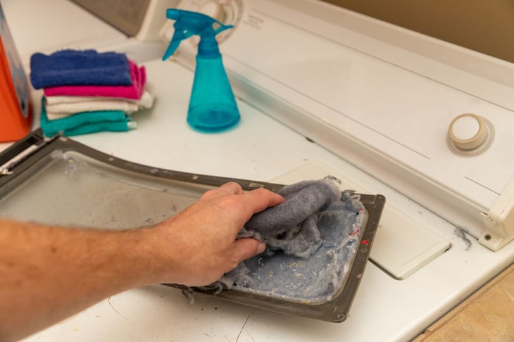 Someone cleaning the lint trap of their laundry dryer