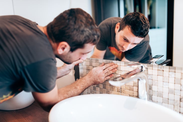 Man renovating his bathroom tiles.