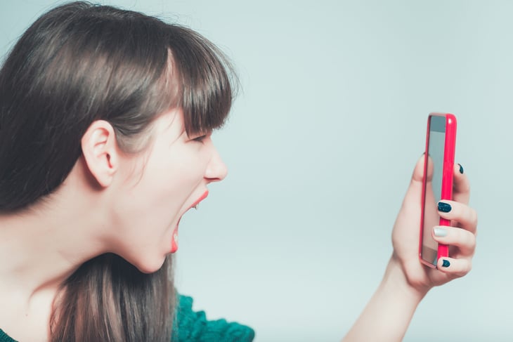 Woman screaming in unbridled rage at her phone