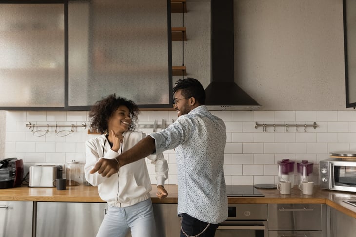 Happy homeowners dancing in their kitchen