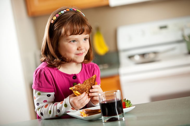girl eating grilled cheese sandwich