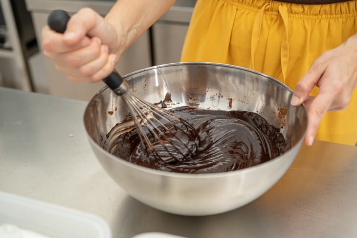 Woman stirring a brownie mix with a whisk