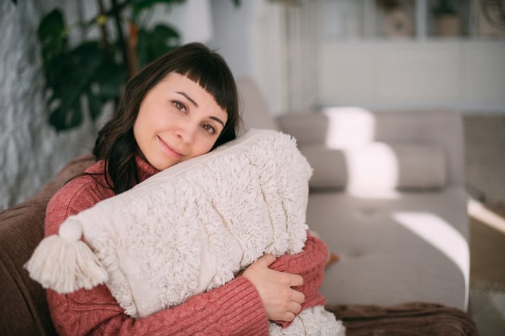 woman in sweater with pillow