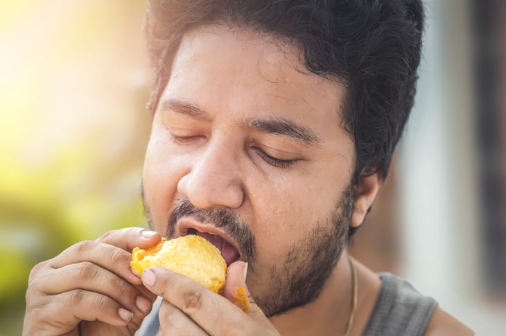 Man eating a mango