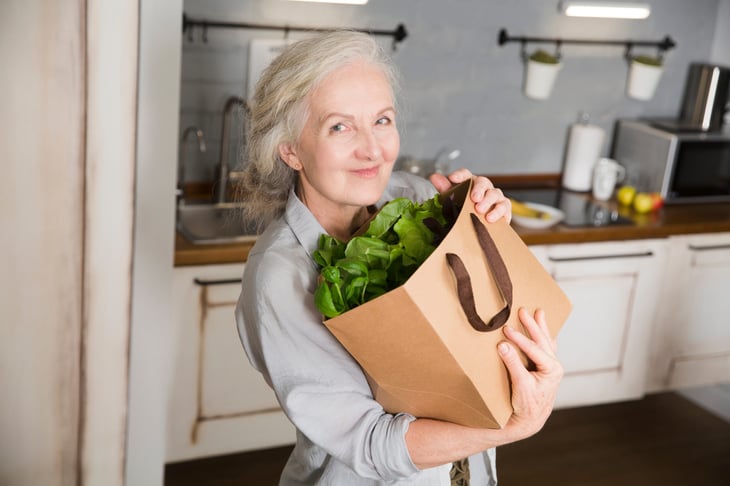 Senior woman with a bag full of lettuce